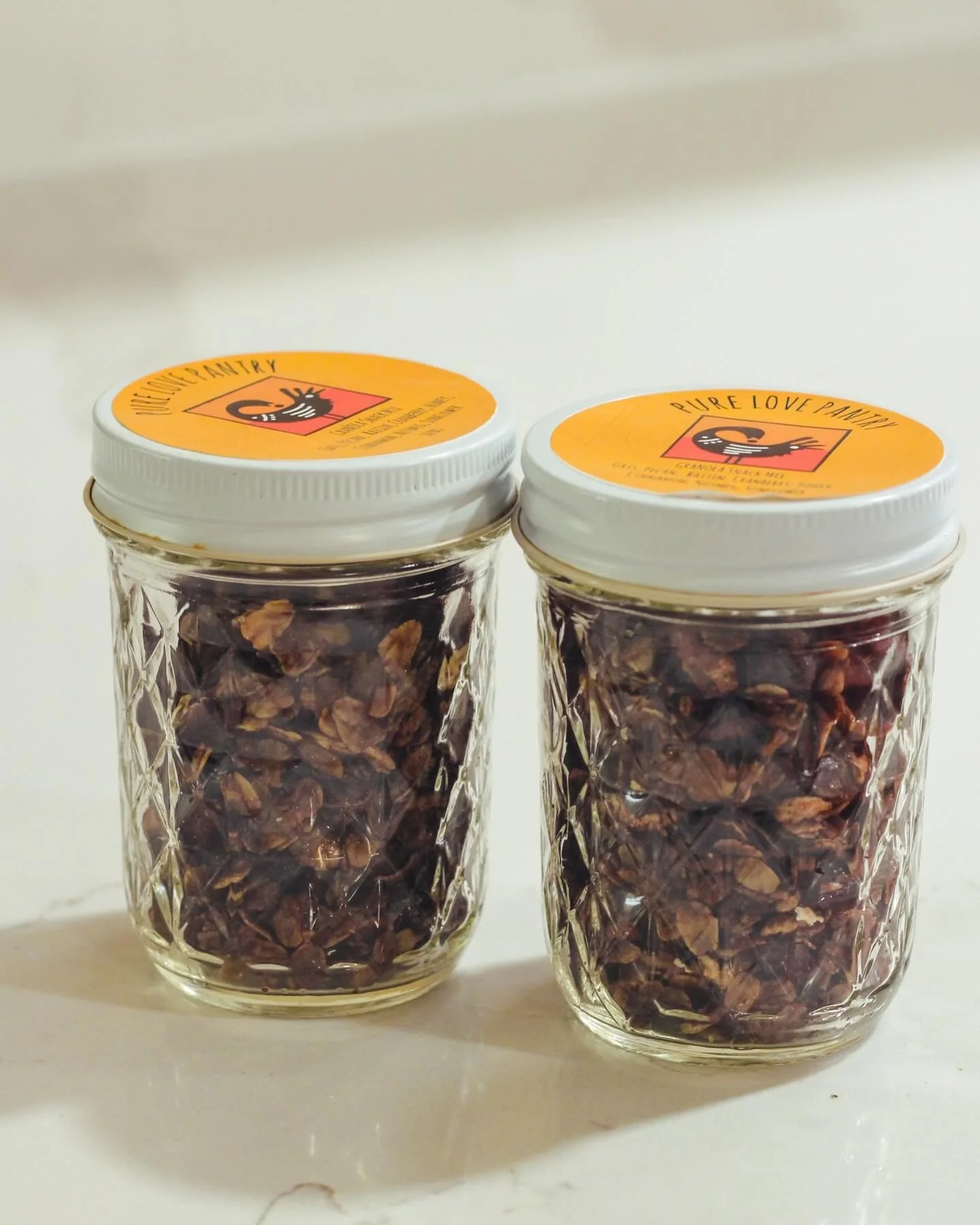 Two jars of Pure Love Pantry granola snack mix