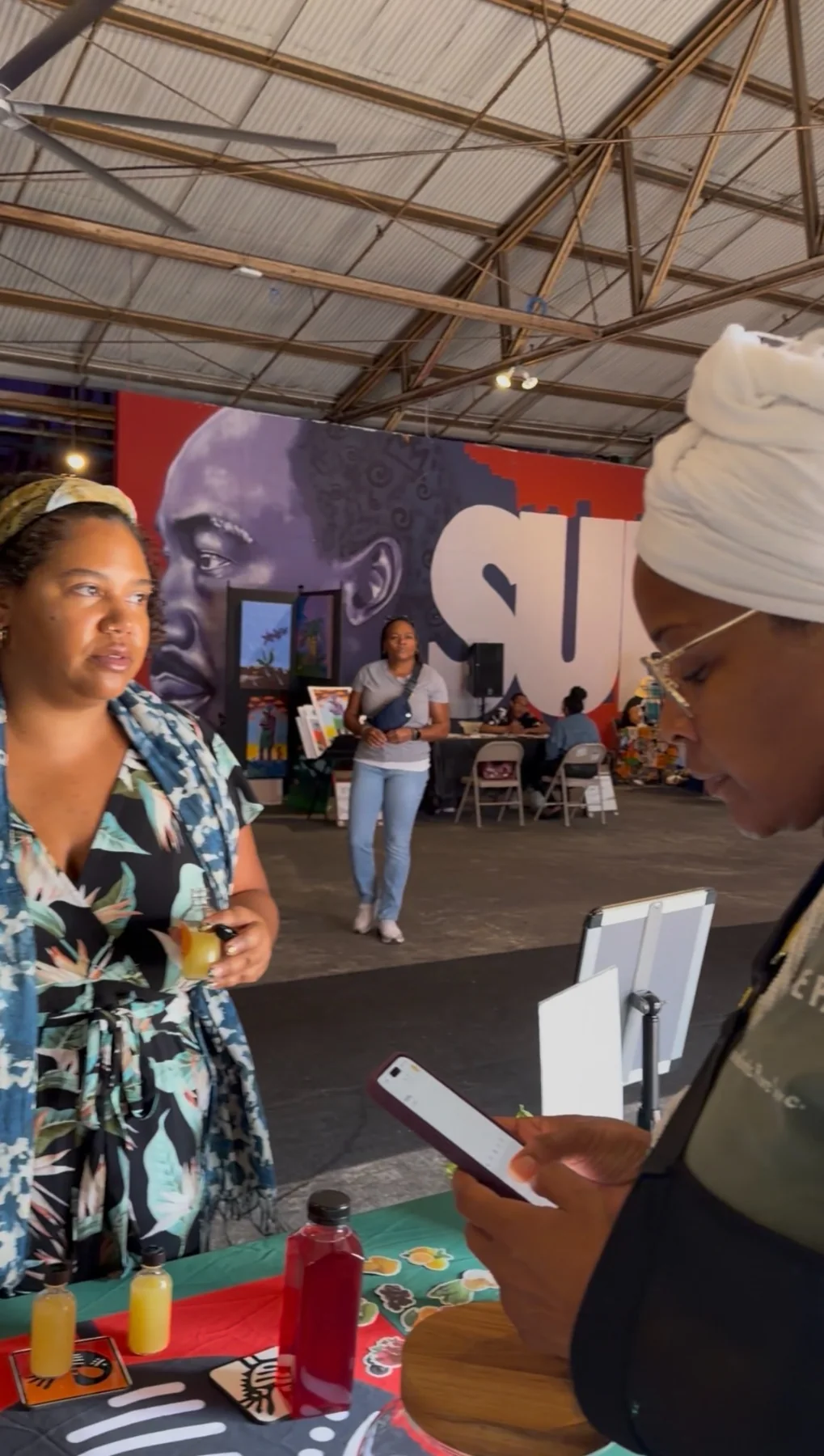 Wendy Firven assisting a visitor at a community market