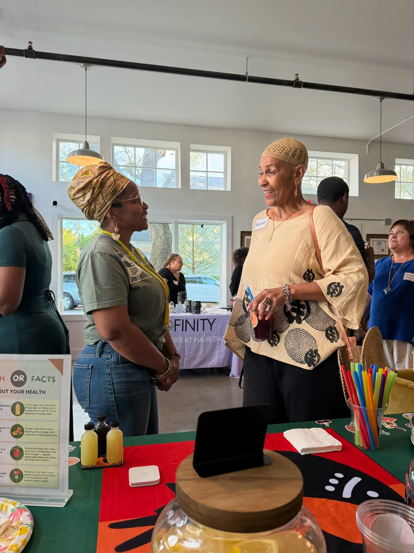 Wendy Firven and a guest in conversation at a Pure Love Pantry table