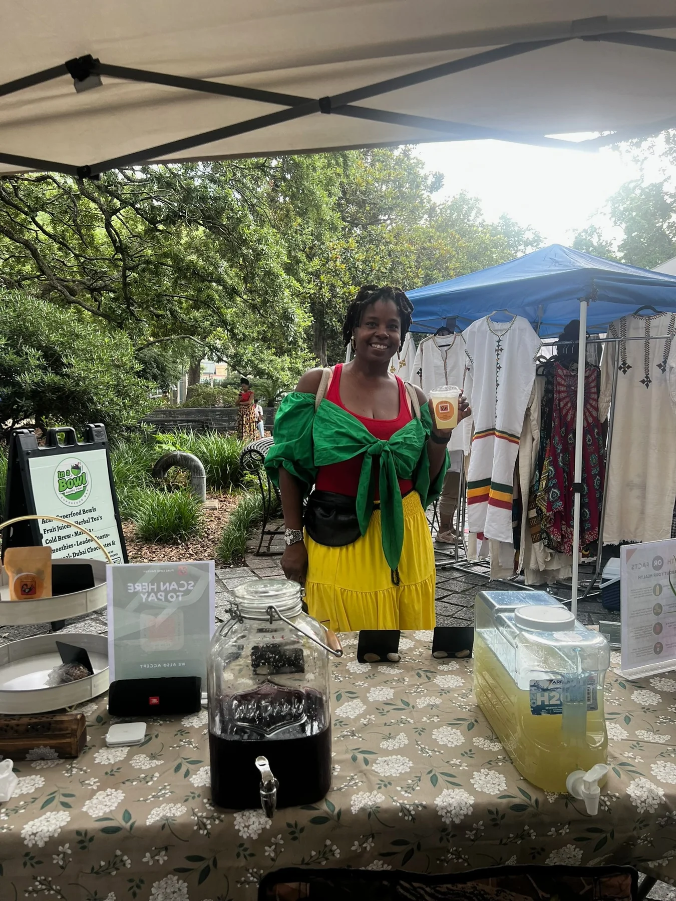 A market guest holding a Pure Love Pantry drink
