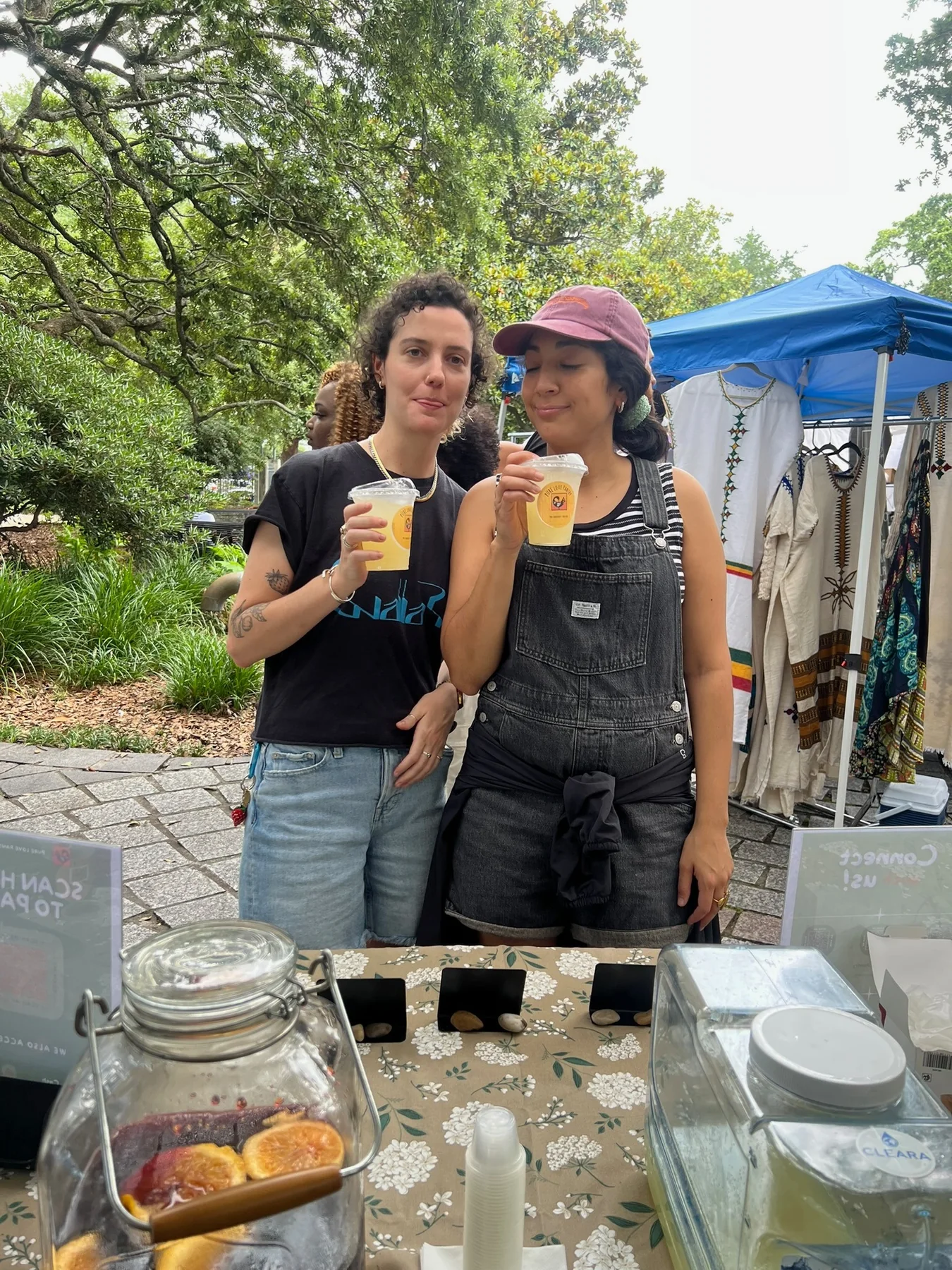 Two friends sampling gingerade at a community market