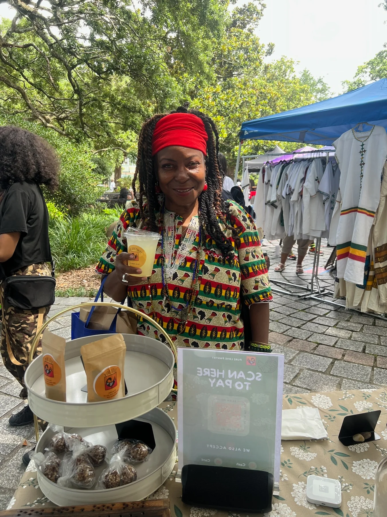 A guest enjoying a Pure Love Pantry drink at a cultural market