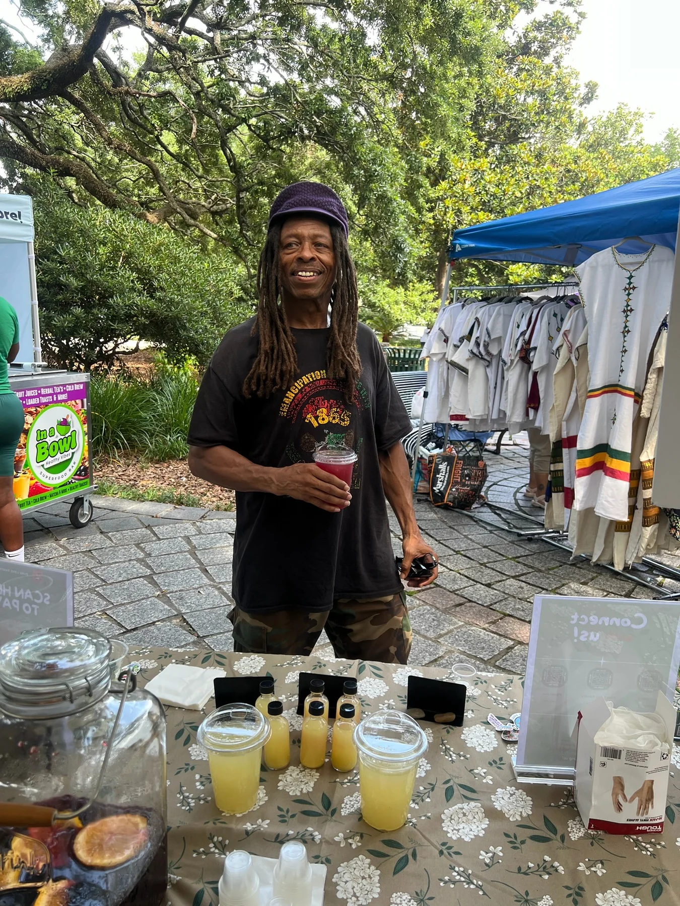A guest holding hibiscus tea at the Pure Love Pantry table